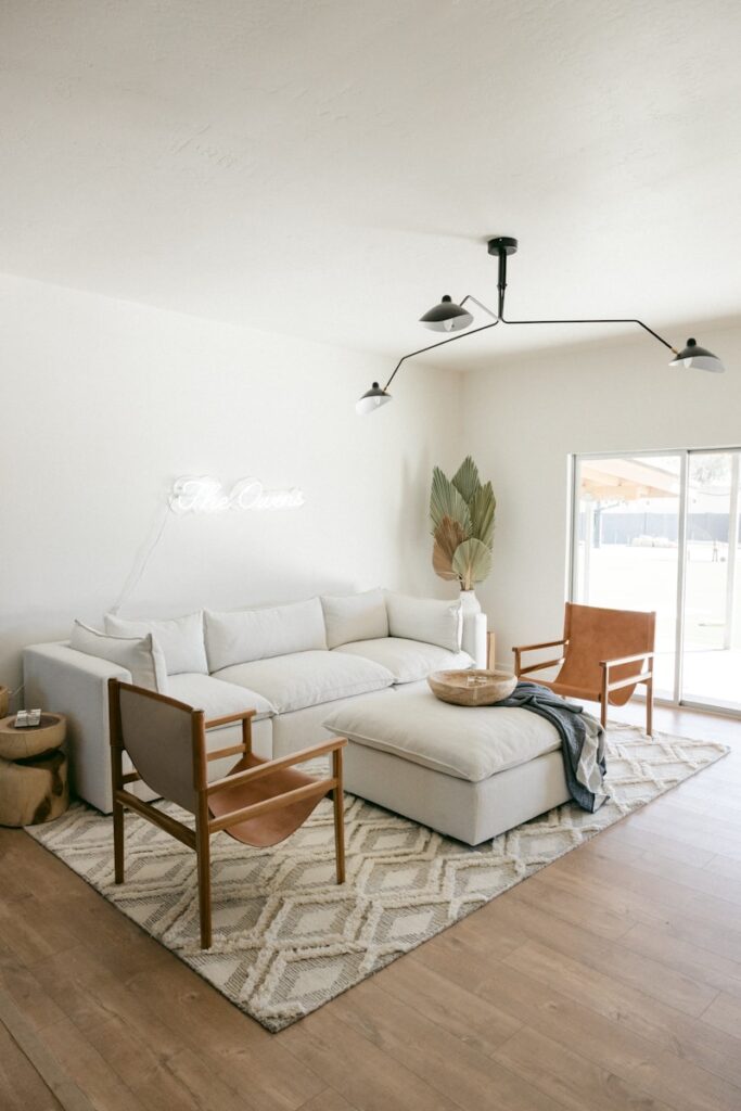 white sofa near brown wooden chair